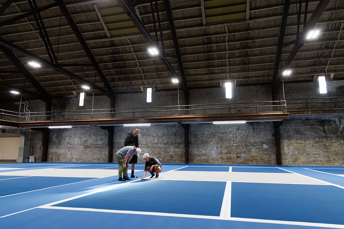 Armory Pickleball co-owner Craig Cooper, right, talks about the surface of the courts during an open house at the Bellingham Armory on North State Street on Oct. 22. The club will have five courts for players.