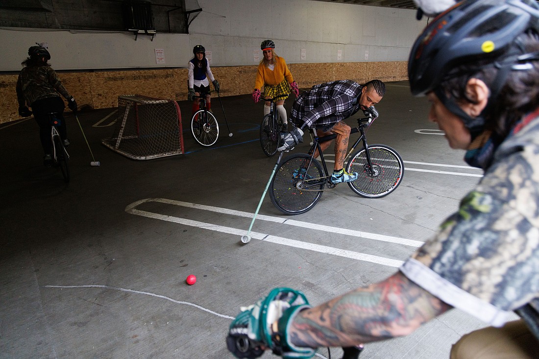 Justin Johnson, of team Whatever, reaches back to get the ball while holding still on his bike during the Bellingham Bike Polo club's Fall Tournament on Oct. 29. Teams from California to Alaska came to play in the three-day tourney.