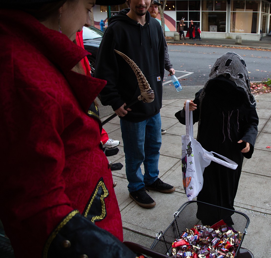 A little grim reaper picks up candy from Erika Millage at Third Planet.