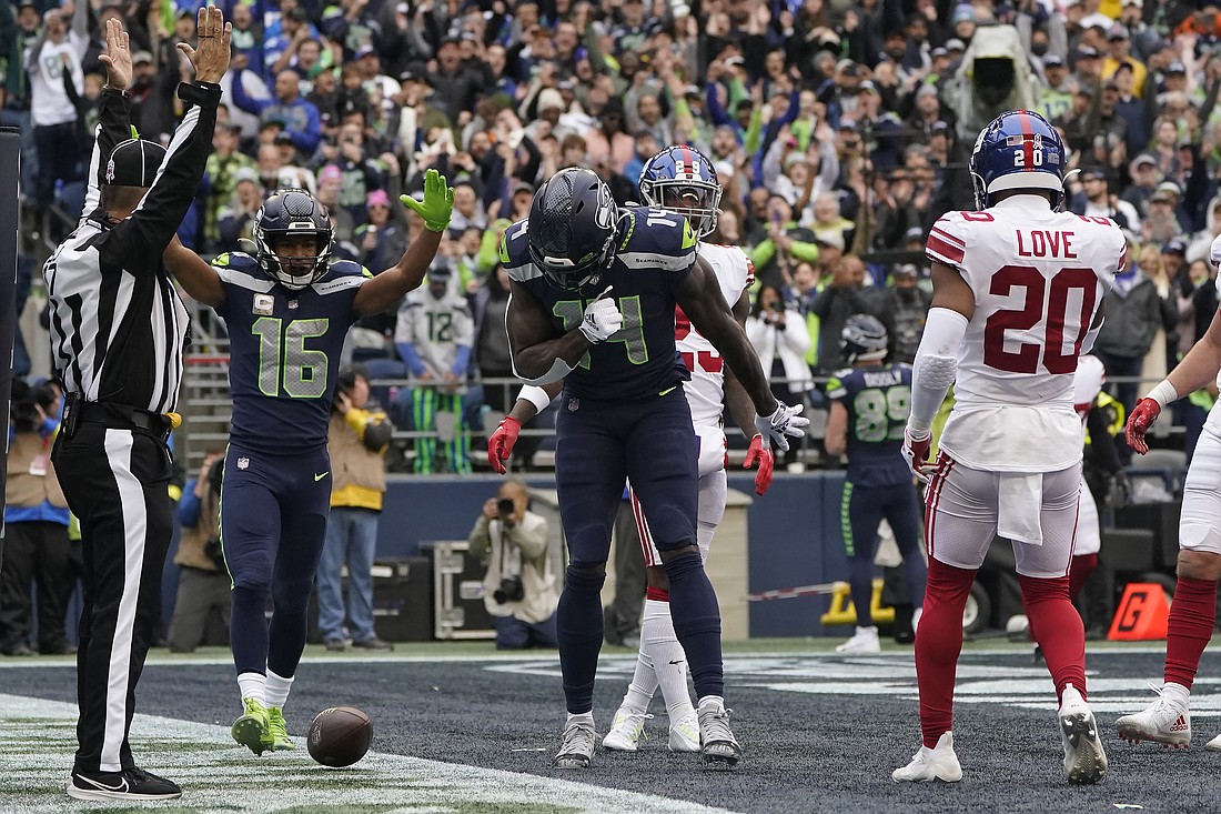 Seattle Seahawks wide receiver DK Metcalf, middle, celebrates after catching a touchdown pass between wide receiver Tyler Lockett (16) and New York Giants safety Julian Love (20) during the first half of an NFL football game on Oct. 30.