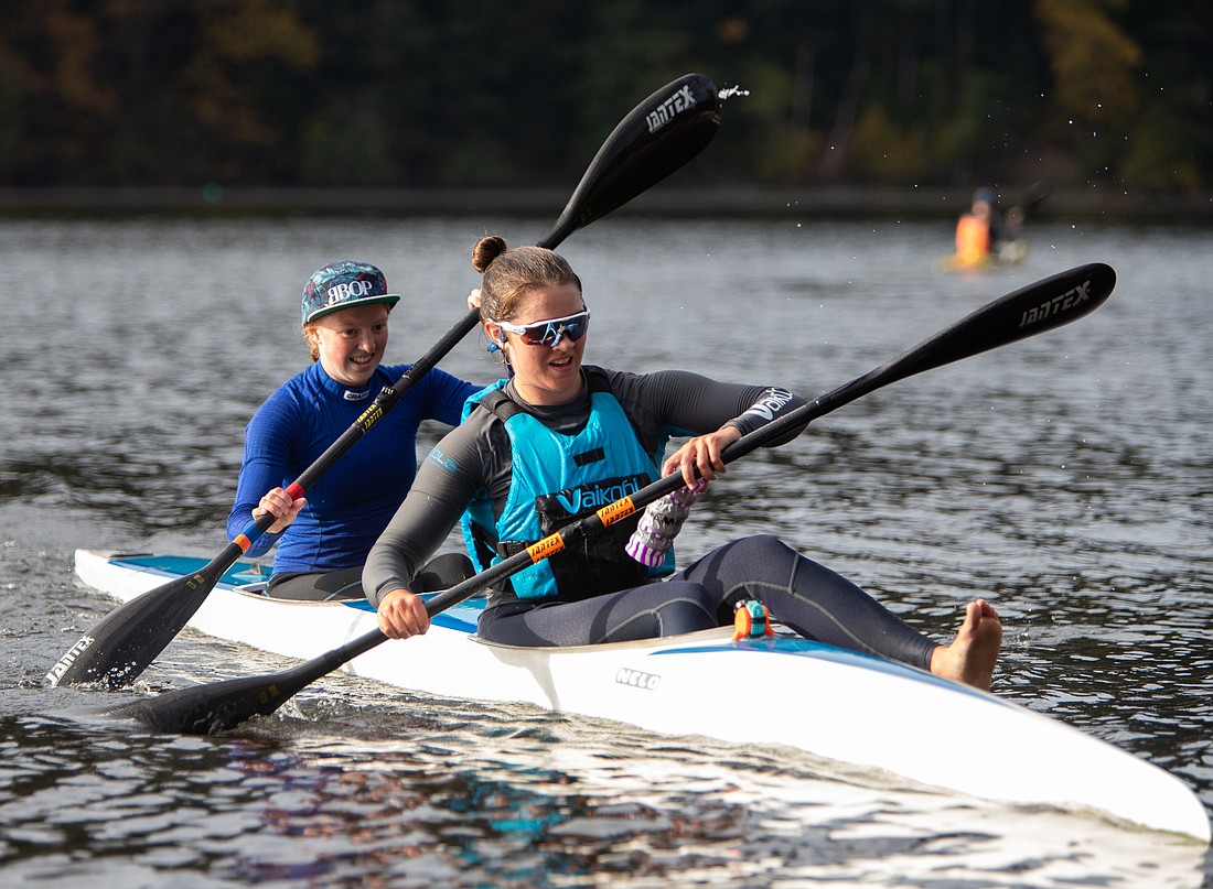 Ana Swetish, right, steps out of the kayak with Abby Scoggins to pass off a baton in the Paddle 4 Food relay race at Lake Padden on Oct. 23. Dozens of kayakers came out to compete and raise money for the Bellingham Food Bank.