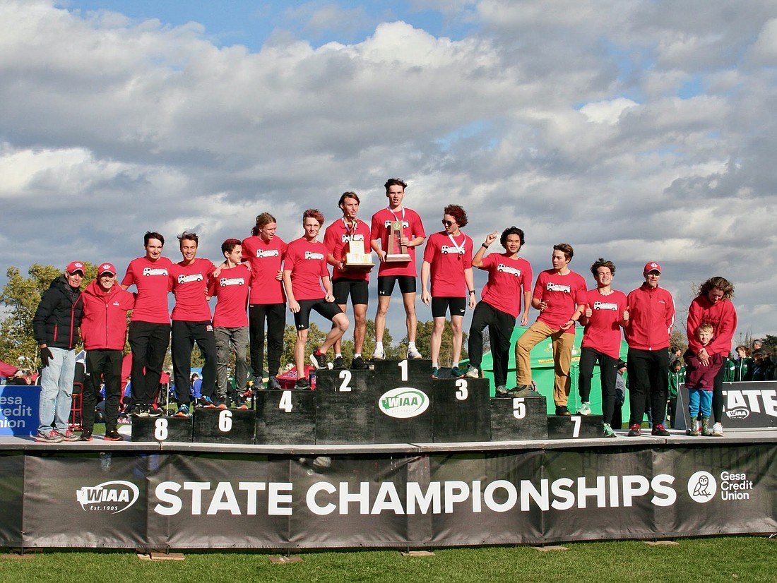 The Bellingham boys cross country team poses on the podium with their 2A state championship trophy at the WIAA 2A boys state cross country meet on Nov. 5 at Sun Willows Golf Course in Pasco, Washington.