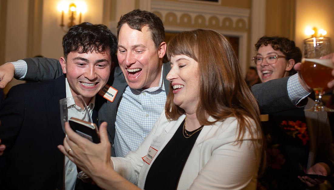 Joe Timmons, center, reacts to preliminary election results with his campaign manager Davin Rose, left, and wife Heather McGuinness at Hotel Leo on Nov. 8