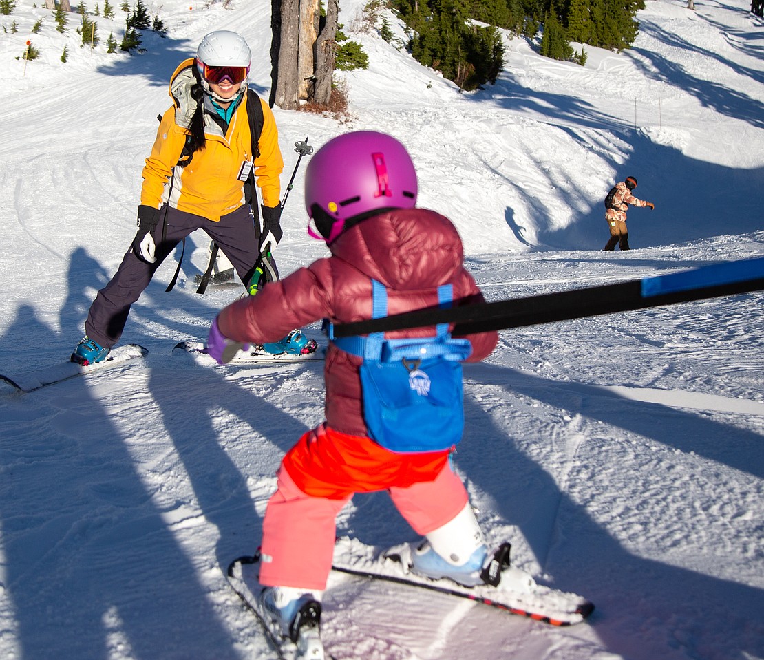 With her dad holding her with straps, 2-year-old Sofie skis toward her mom, Emily, off of Chair 2.