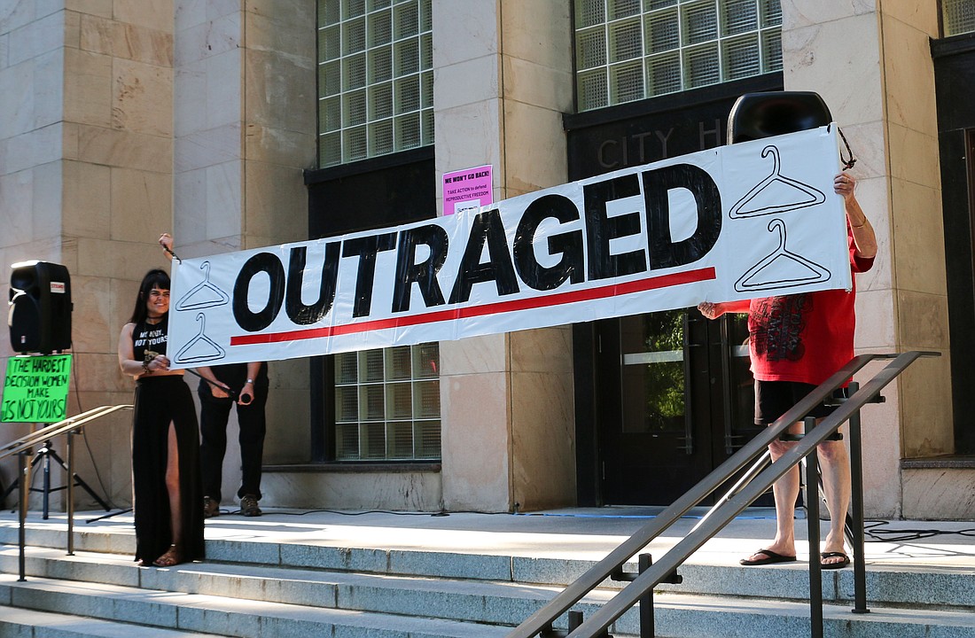 Protesters at an abortion rally hold a sign in front of the Bellingham City Hall entrance on June 24. The City Council passed a resolution affirming abortion rights on Nov. 21.