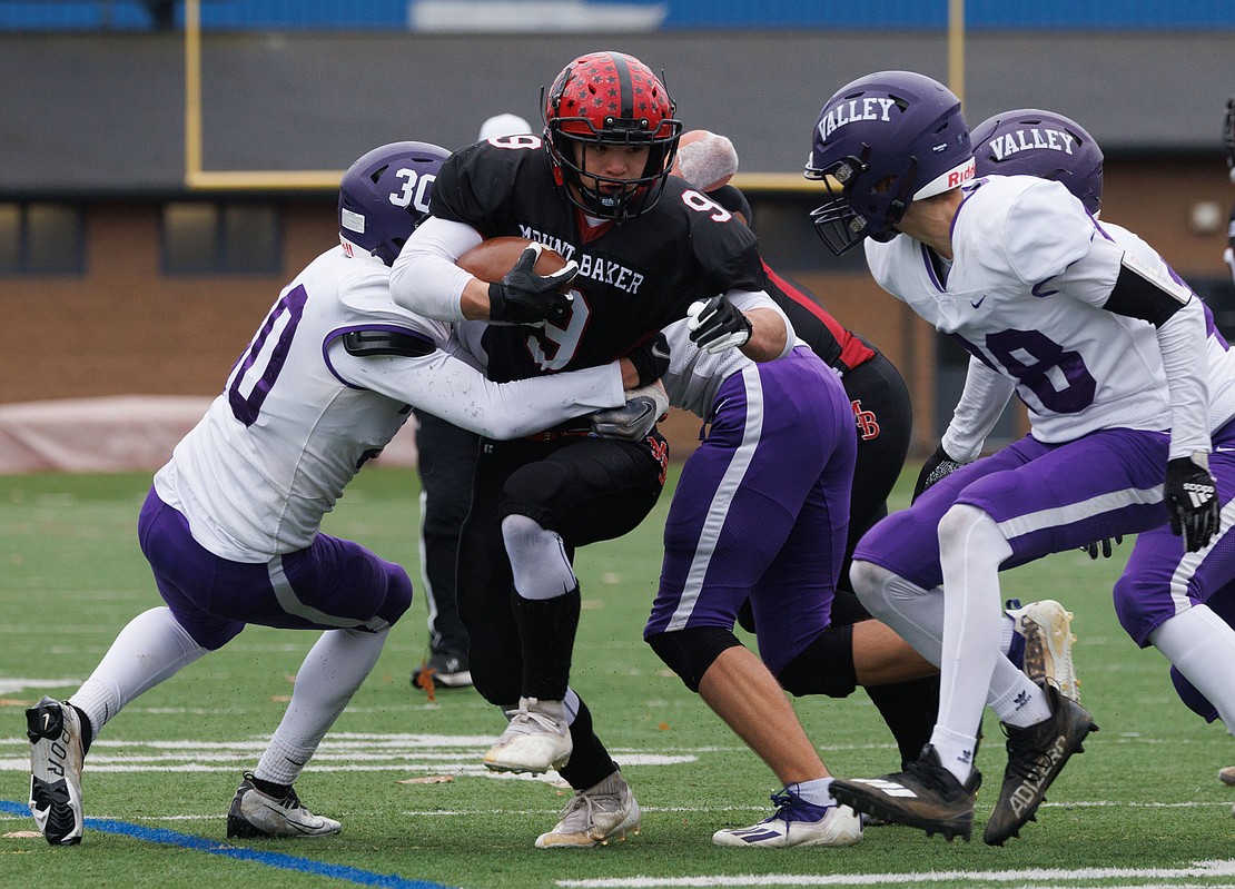 Nooksack Valley defenders tackle Mount Baker's Marcques George.