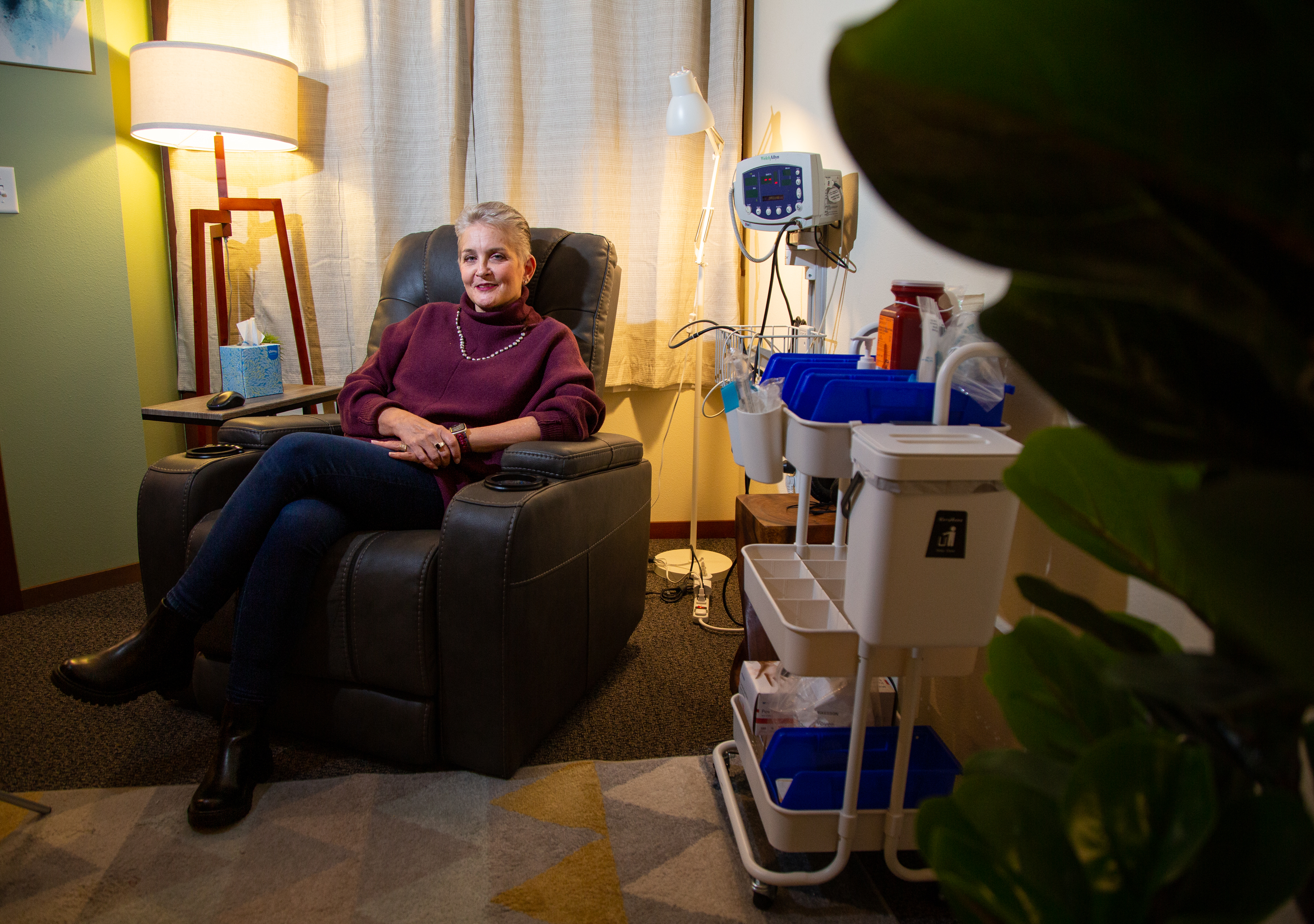 Dana Berger sits in a recliner next to carts of medical equipment at King Health on Nov. 21. Patients undergo the ketamine treatment in the small, cozy room. Karen King – owner and therapist – designed the space to be warm, comforting and safe.