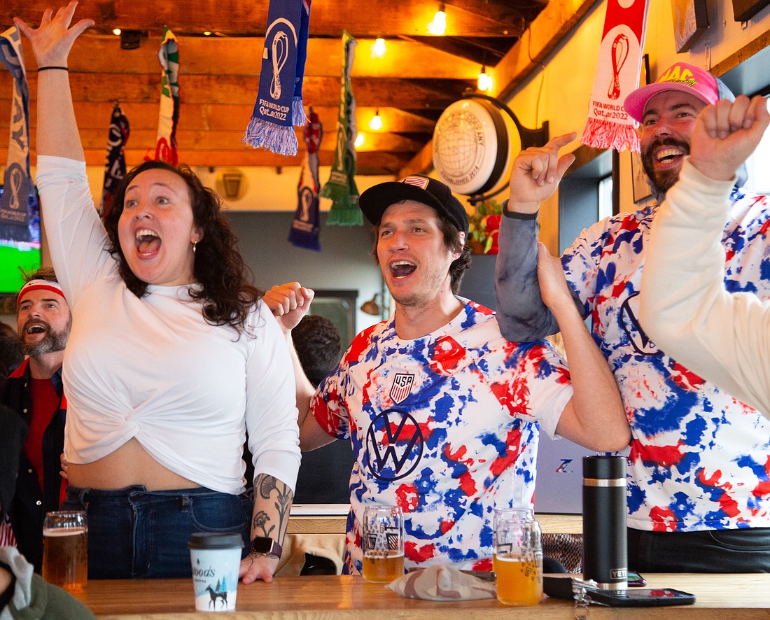 From left, Hanna McIlvaine, Cory James and Connor Adams celebrate a U.S. win over Iran at Gruff Brewing's World Cup watch party on Nov. 29. The U.S. will play the Netherlands on Dec. 3.