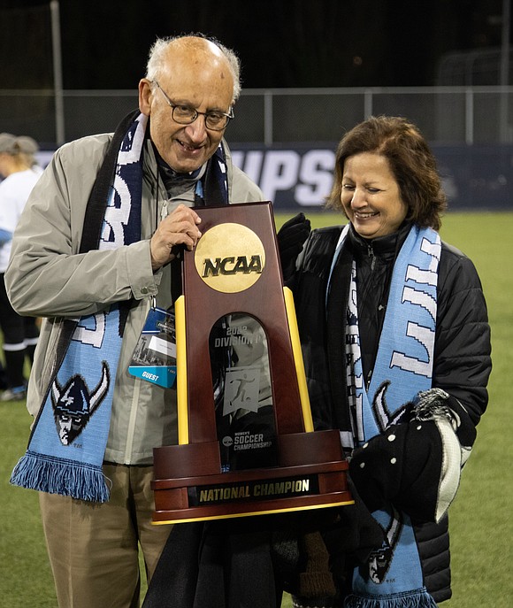 Western President Sabah Randhawa, left, and his wife, Uzma Ahmed, hold the women's soccer national championship trophy – the second in Randhawa's time as president.