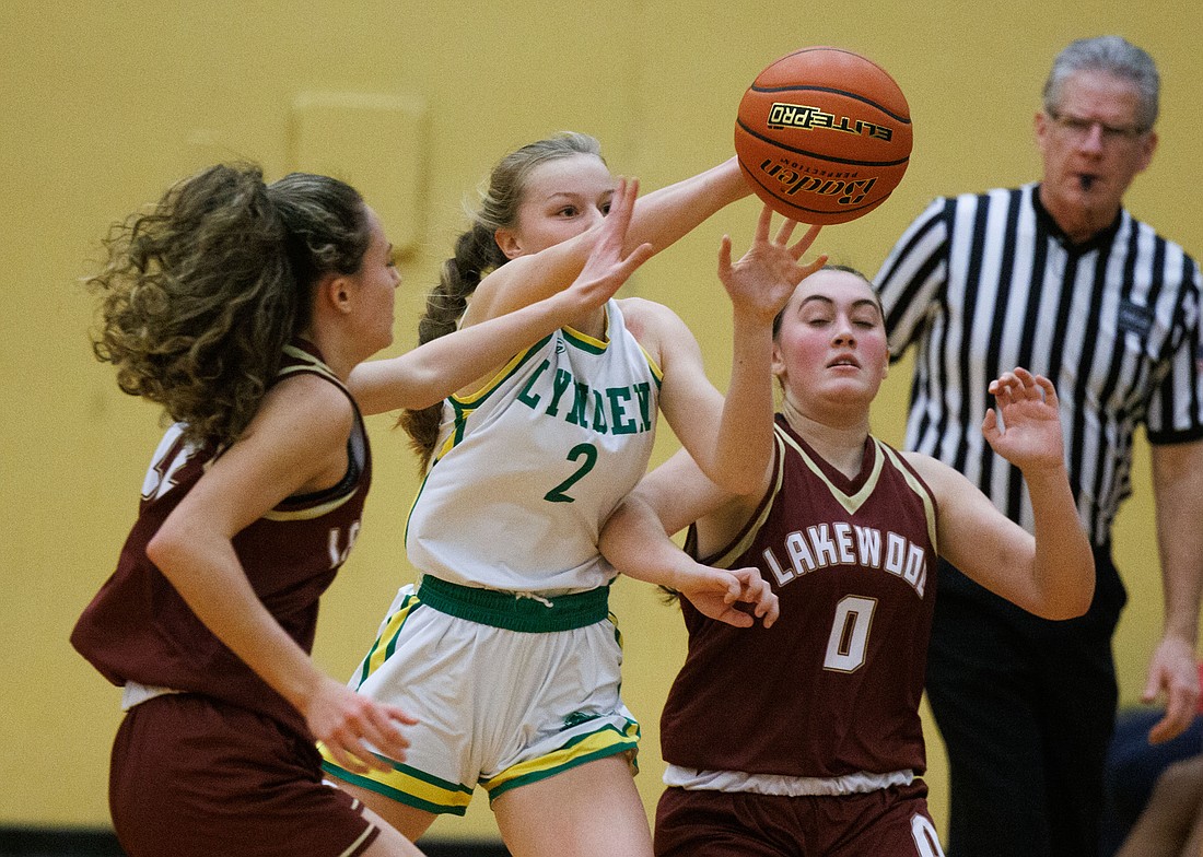 Lynden’s Kalanie Newcomb steals the ball from two Lakewood players along the sideline as the Lions beat Lakewood 52-23 on Dec. 8.