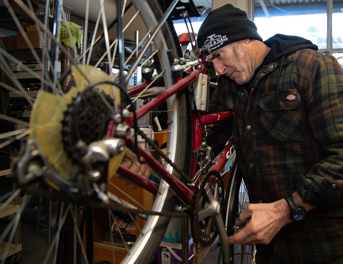 Executive Director Kyle Morris works on a bike at The Hub Community Bike Shop in its new location on Commercial Street on Dec. 1.