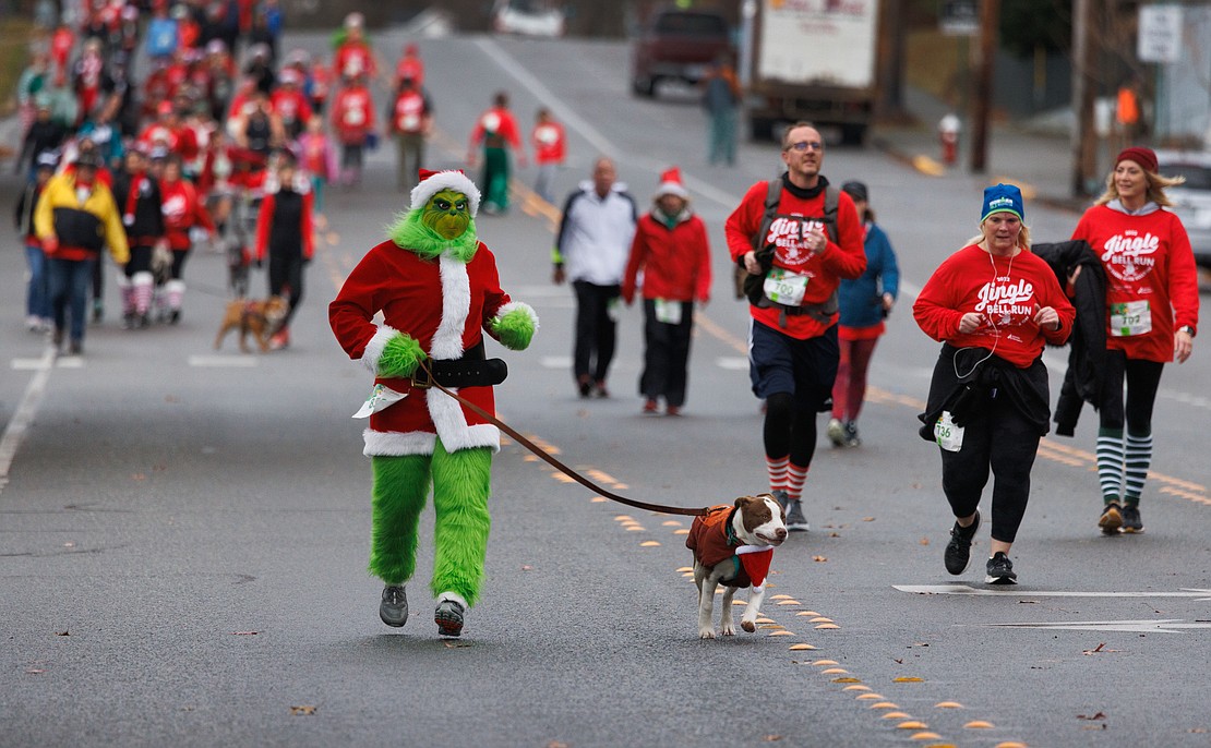The Grinch, aka Becky Prikril, runs with Benny to the finish line of the Arthritis Foundation's Jingle Bell Run 5K on Dec. 10.
