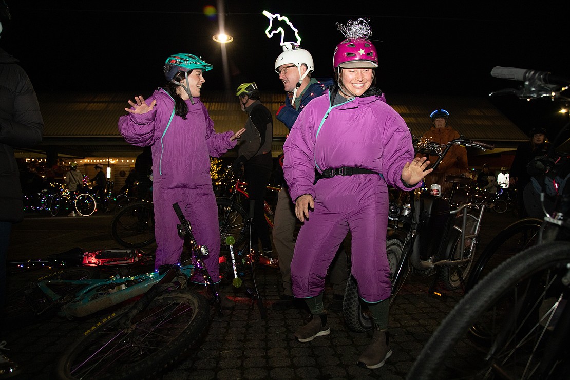 From left, Jessica Burke, Andy Albers and Georgina Howler dance while waiting for the Lighted Bike Parade to begin from the Depot Market Square on Dec. 10. Hundreds of bikes joined Downtown Bellingham's annual ride for Boulevard Park.