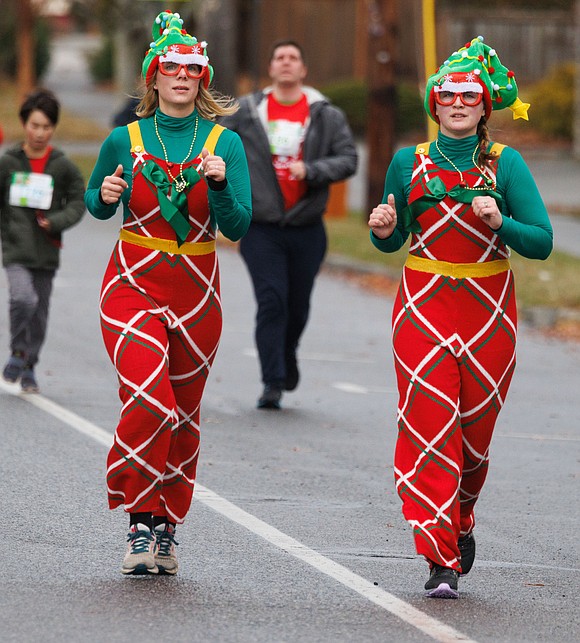 Wearing matching outfits, Melanie Dickinson, left, and Jillian Neff run in the Arthritis Foundation's Jingle Bell Run 5K on Dec. 10. The matching outfits are a 12-year tradition for the two, with Neff coming up for the run from Eatonville.