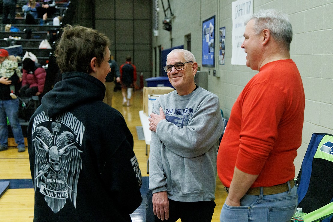Phred Morin, center, smiles as he listens to Brody Strandt tell a story about how his father lost twice in the state wrestling tournament to Graham Morin.