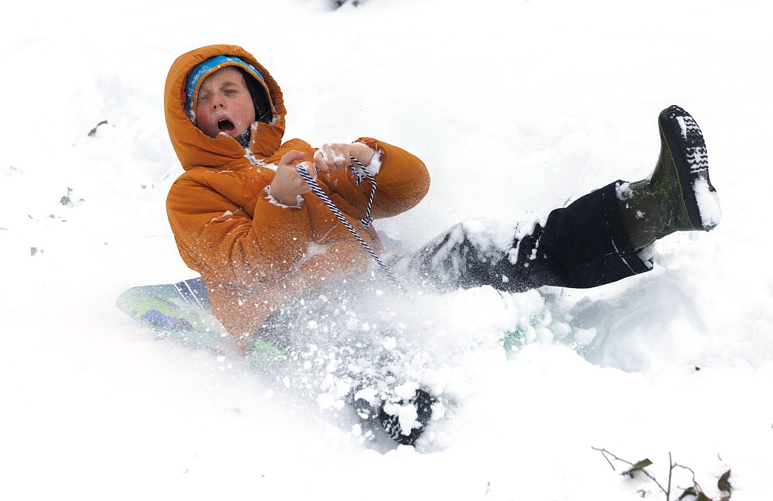 Evan Conlan, 10, reacts as snow kicks up into his face while sledding down a hill on 38th Street on Dec. 20.