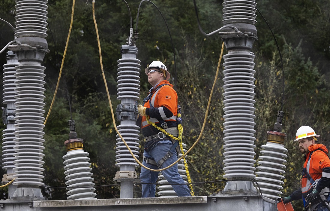A Tacoma Power crew works at an electrical substation damaged by vandals early on Christmas morning, Sunday, Dec. 25, 2022, in Graham, Pierce County.