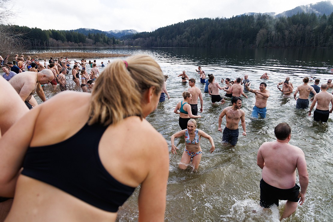 Hundreds of people enter and exit the chilly water of Lake Padden at the Padden Polar Dip on Jan. 1.