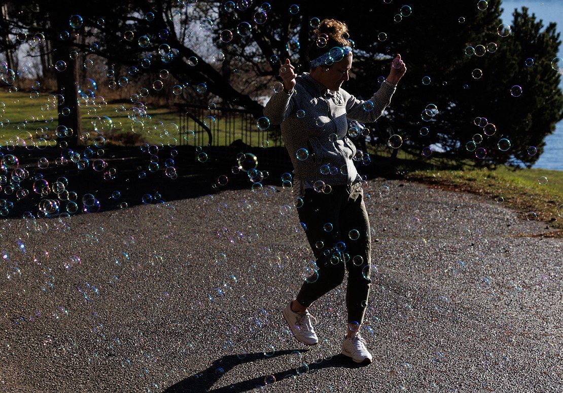 Kerry Hastings dances in a cloud of soap bubbles before taking part in the Padden Polar Dip.