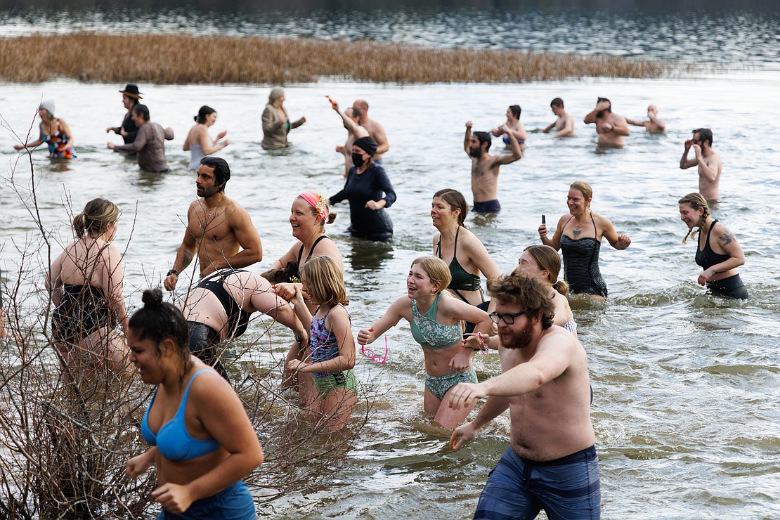 Reactions vary as people enter and exit Lake Padden's cold water during the 2023 Padden Polar Dip.