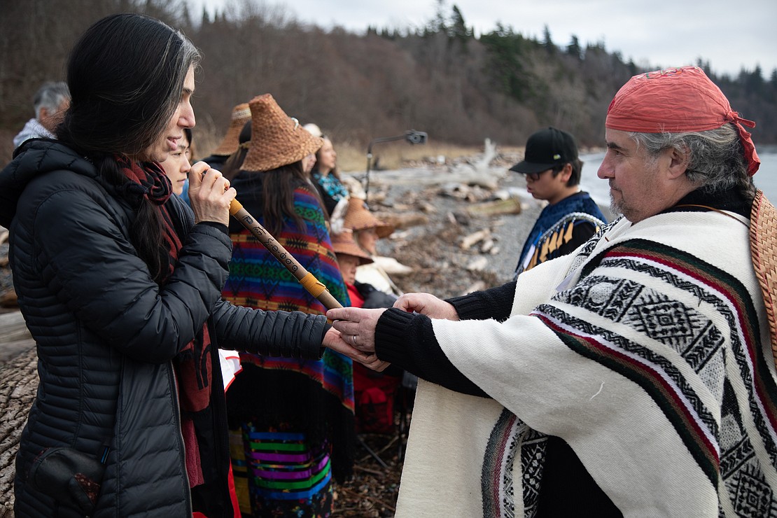 Julie Trimingham, left, from the Sacred Lands Conservancy, takes a pipe from David Pilz during a prayer ceremony at Cherry Point on Jan. 3. Members of the Lummi Nation and supporters gathered to pray for the journey home of the killer whale Sk’aliCh’elh-tenaut — also known as Tokitae — who is currently held at the Miami Seaquarium.