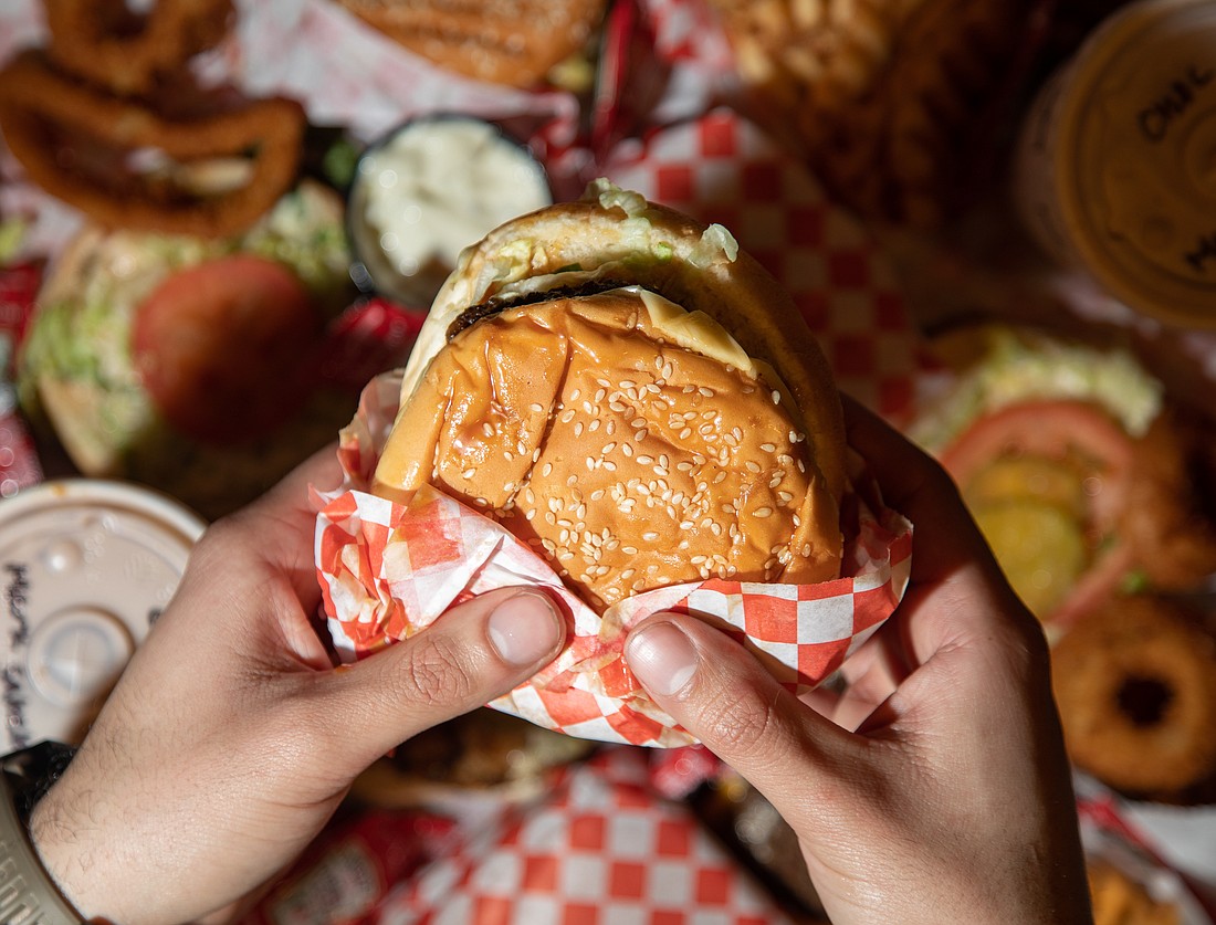 Contributor Mark Saleeb holds a teriyaki burger from Boomer's Drive-In. Every January and February, the local burger spot celebrates its anniversary by selling burgers for $3.44.