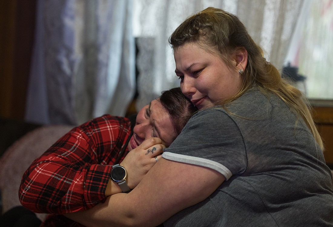 Alyshia Losey, left, is hugged by younger sister Elizabeth Babcock on Jan. 7 as members of the family of David Babcock, killed by a Sedro-Woolley police officer during an attempted traffic stop last February, discuss his death. The Skagit County prosecutor later cleared the officer, who has returned to work, of wrongdoing.
