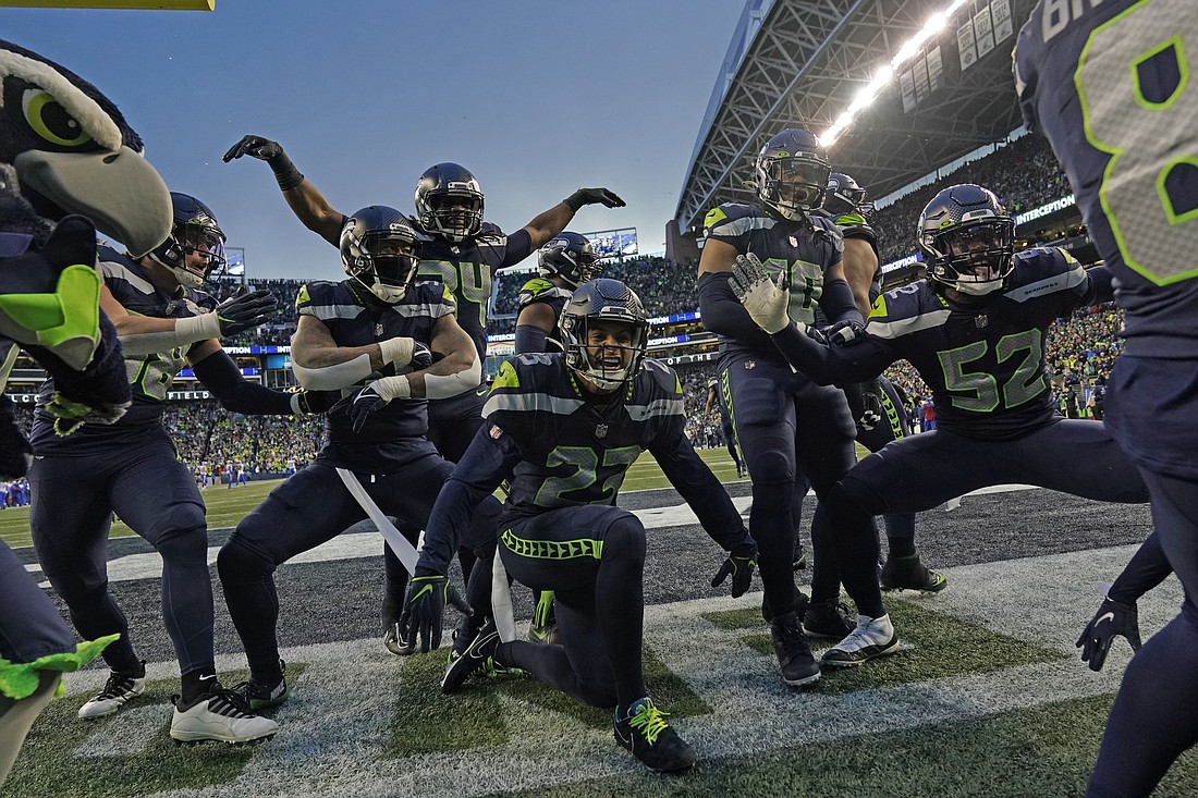 The Seattle Seahawks celebrate after an interception by safety Quandre Diggs during overtime of an NFL football game against the Los Angeles Rams at Lumen Field on Jan. 8.
