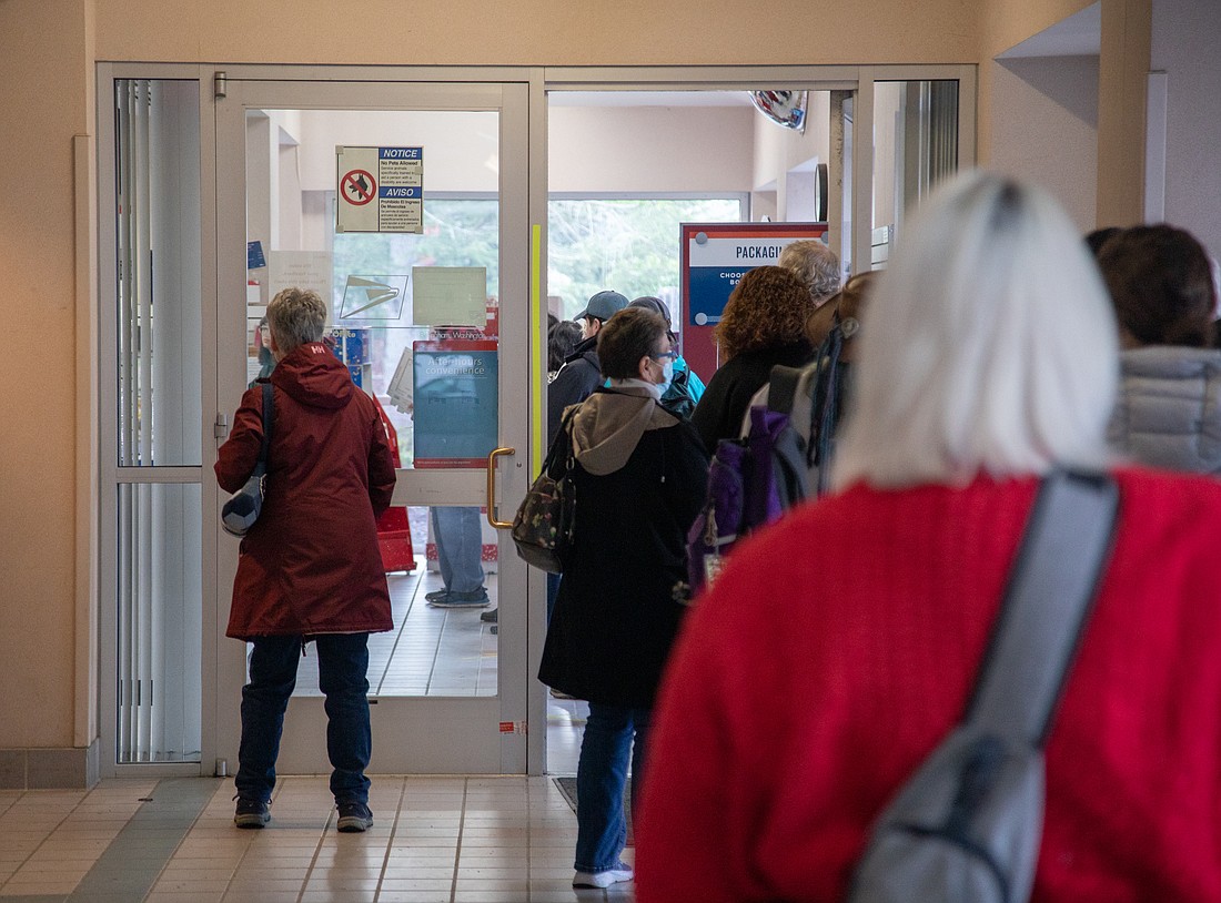 Around two dozen people wait in line for packages at the U.S. Post Office off of Orleans Street in Bellingham on Jan 3. Delays have persisted, leading U.S. representatives Rick Larsen and Suzan DelBene to write a letter to Postmaster General Louis DeJoy on Jan. 11.