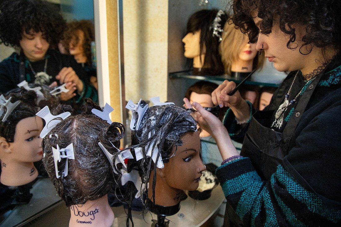 Squalicum senior Zee Miles applies conditioner to their training mannequin head during class at the Bellis Fair Mall on Jan. 11. The cosmetology class reviewed proper techniques for applying the conditioner in preparation for hair dyeing.