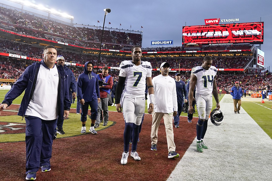 Seattle Seahawks quarterback Geno Smith (7) and wide receiver DK Metcalf (14) walk off the field after an NFL wild card playoff football game against the San Francisco 49ers in Santa Clara, Calif., Jan. 14. The 49ers won 41-23.