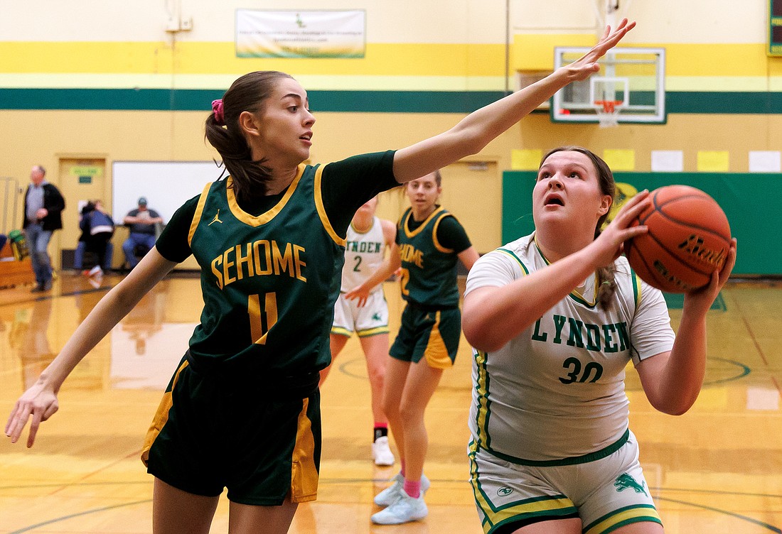 Sehome's Kylie Watson (11) tries to stop a shot by Lynden’s Payton Mills (30) on Jan. 27. Lynden beat Sehome 62-32 at home.