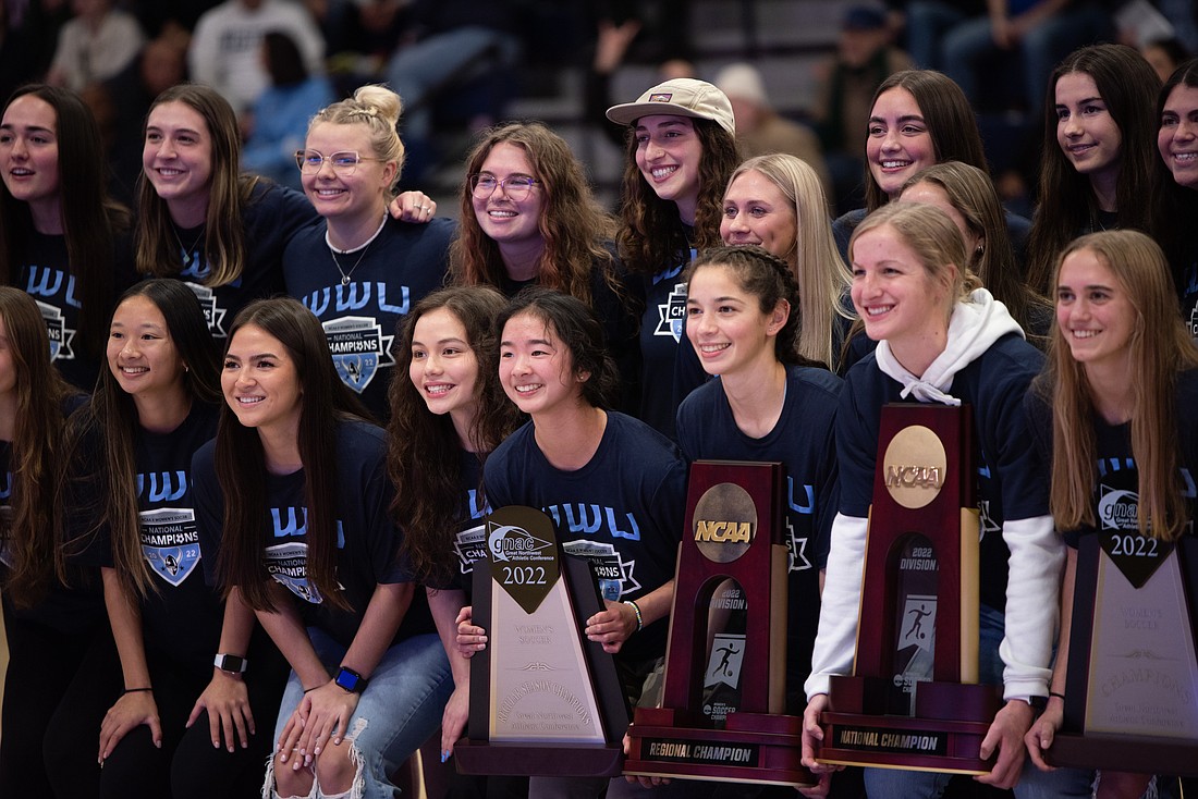 The 2022 Western Washington University women's soccer team poses with trophies during the halftime of a men's basketball game Jan. 27. Western women's soccer took home a second national championship title in December.