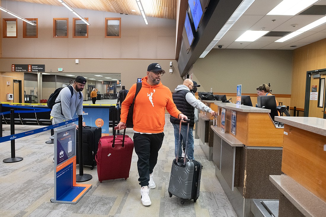 Karn and Arun Dodd from Victoria, B.C., wheel their bags to the Allegiant checkout counter at Bellingham International Airport on Jan. 27. Proximity to the border and low fares make the airport particularly attractive to Canadians hoping to fly in the U.S.