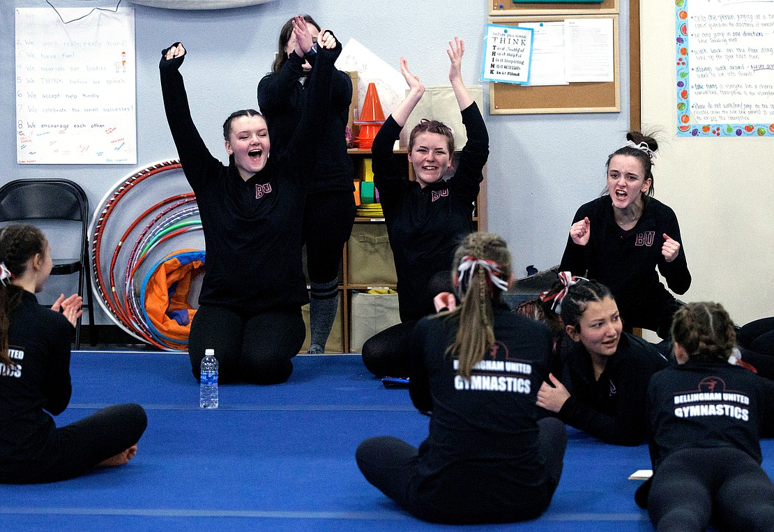 The Bellingham United Gymnastics team reacts as the overalls result put the team in first place at the Bellingham Invitational.