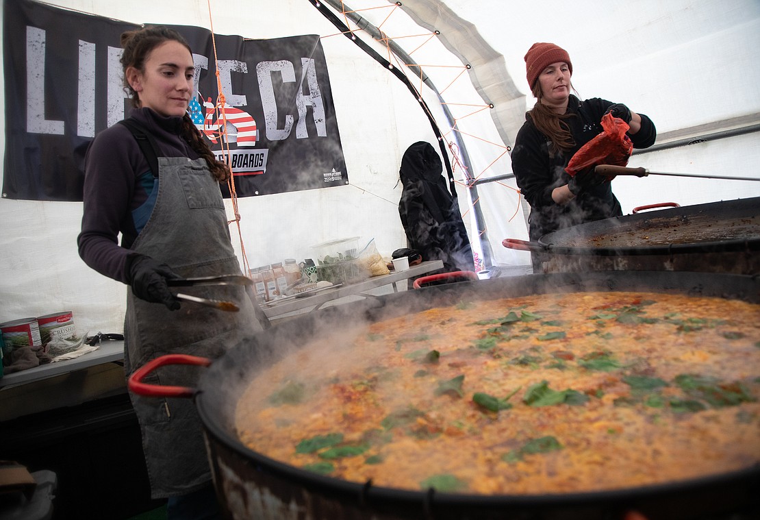 Dana Brownstein, left, and Ona Osin cook paella in the tent at the starting line of the race. Racers enjoyed the fresh paella, fondue and hot drinks while waiting for their races to begin.