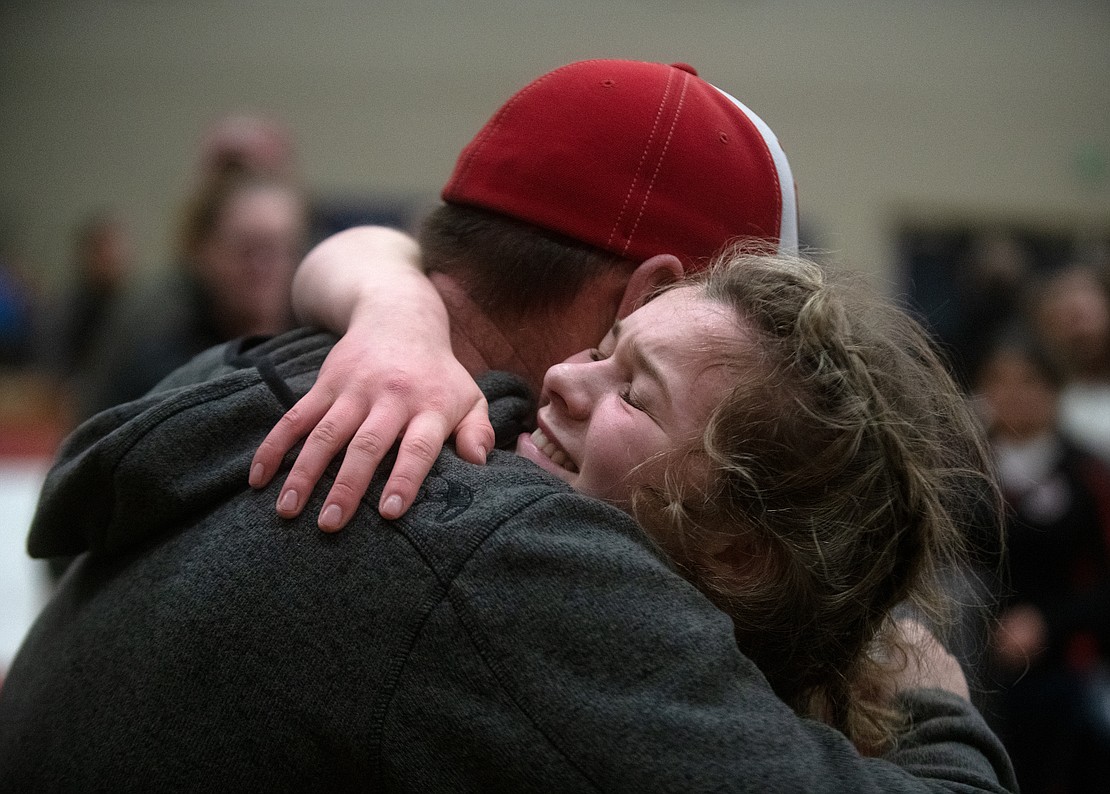 Mount Baker's Lauren Valum hugs her dad, Bernie Valum, after winning the 130-pound championship.