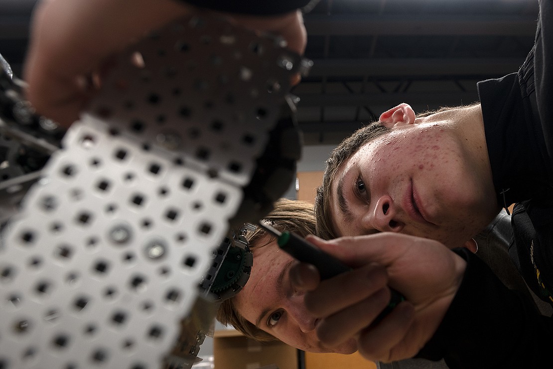 Junior Matthew MacGregor, right, screws a piece to the underside of his team's robot Feb. 6 while junior Thomas Ricks watches during robotics class at Sehome High School.
