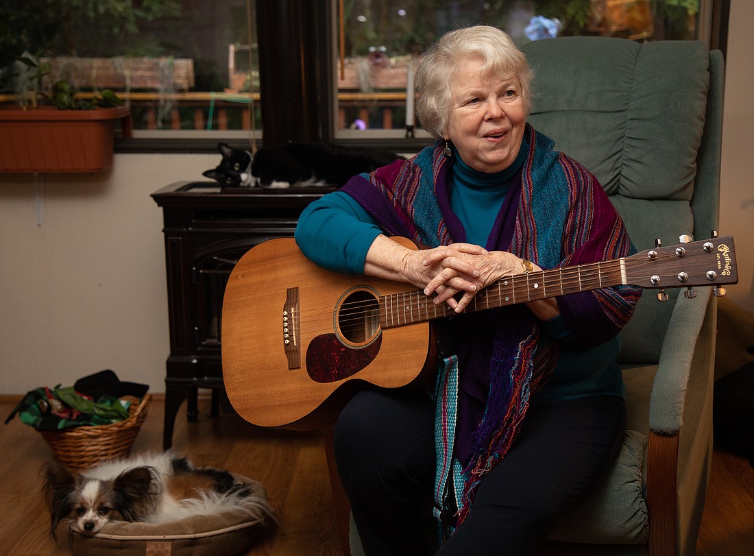 Guitar in hand, longtime Bellingham musician Linda Allen sits in her living room Feb. 3 with her dog Billy and cat Boots. On Saturday, March 4, Allen will be joined by other area musicians to celebrate  her 13th — and likely last — album, "Emergence."