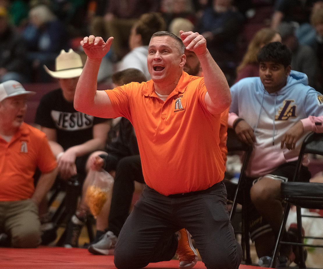 Blaine wrestling coach Tom Hinz demonstrates a move on the sidelines to Victor Gervol during the 285-pound championship match.
