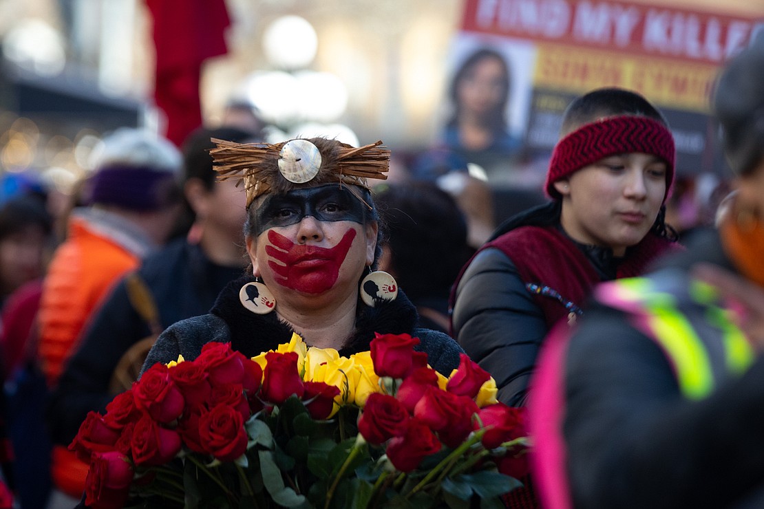A woman with a painted red handprint, symbolizing missing and murdered Indigenous women, marches Feb. 14 during the annual Women’s Memorial March in Vancouver, British Columbia.