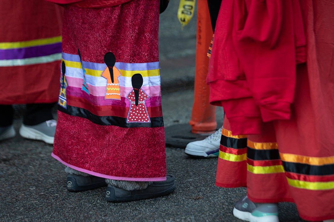 A traditional ribbon skirt portrays two Native American women.