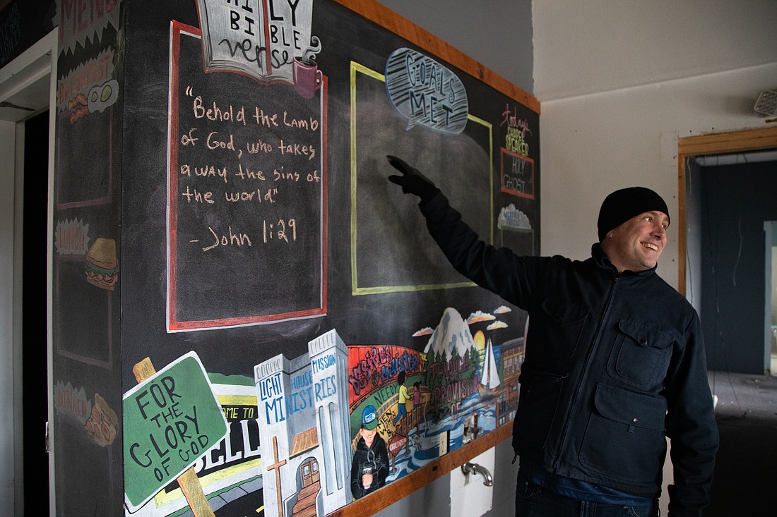 President and CEO Hans Erchinger-Davis points to a chalkboard wall for guests' goals Feb. 17 at the Lighthouse Mission Ministries center. The longtime Bellingham shelter will be torn down in March to make room for a new 300-bed shelter.