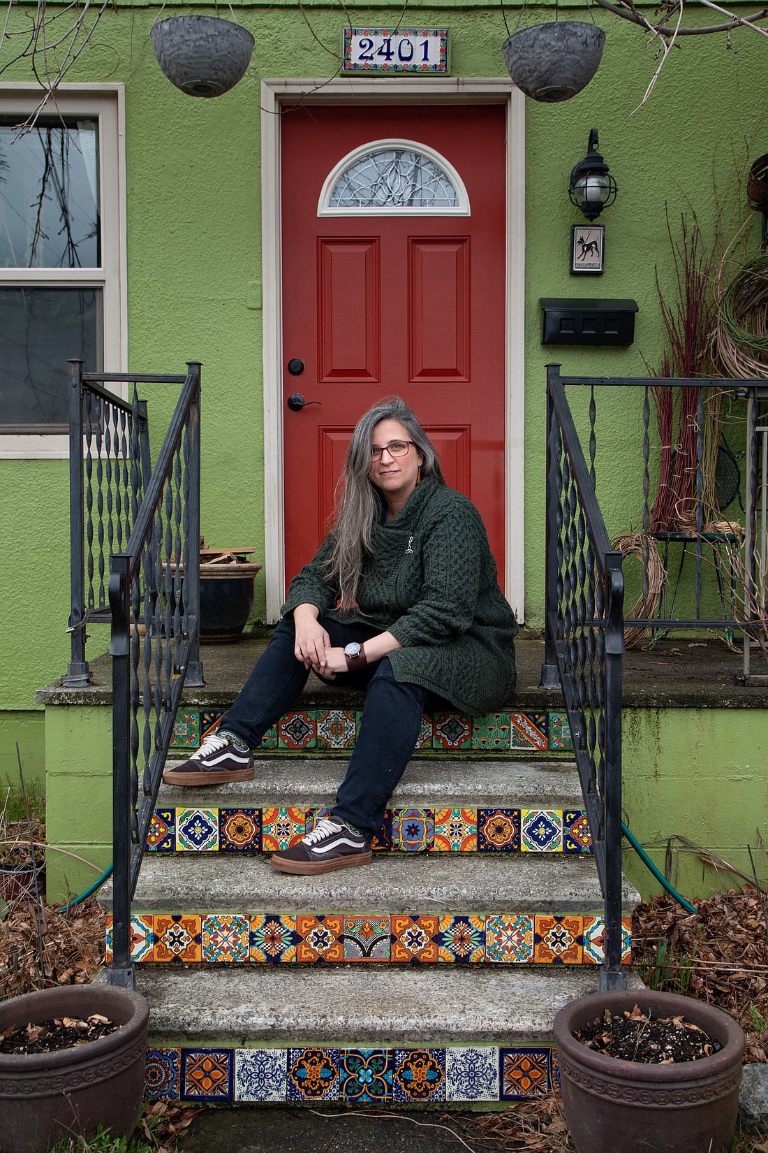 Janet Marino sits on the steps of her Bellingham porch Feb. 17. Behind her are bushels of yard scraps, which she will make into baskets. During the warmer months, when her front gardens are plentiful, Marino leaves excess produce on her porch for any passersby to take.