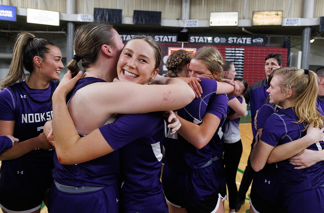 Nooksack Valley’s Devin Coppinger is all smiles as she and her teammates hug and celebrate their 1A state championship title.