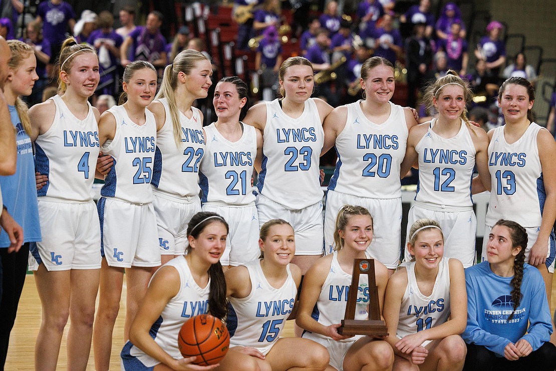 Reactions are mixed as Lynden Christian players gather for the second-place trophy photo.