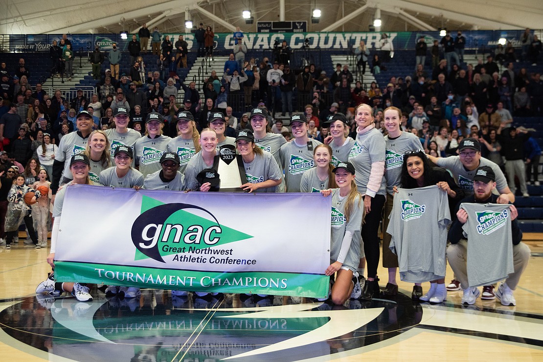The team poses with the GNAC champion banner.