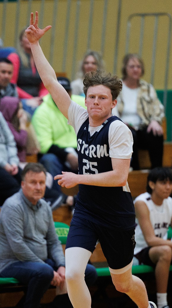 Squalicum’s Xander Sledge holds up three fingers after making a basket from the 3-point arc.