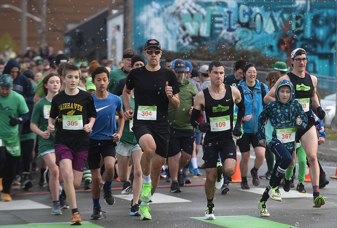Racers leave the starting line of the Runnin' O' the Green at the corner of West Laurel and Cornwall Avenue.