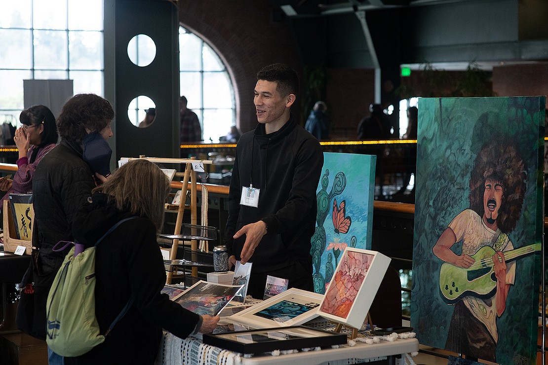 Ivan Colin, an abstract painter and semi-pro soccer player for Bellingham United, sells his work at a vendor table. "The same mentality when I was trying to sign a professional soccer [team] has directly translated into going full time this year [as an artist]," Colin said.